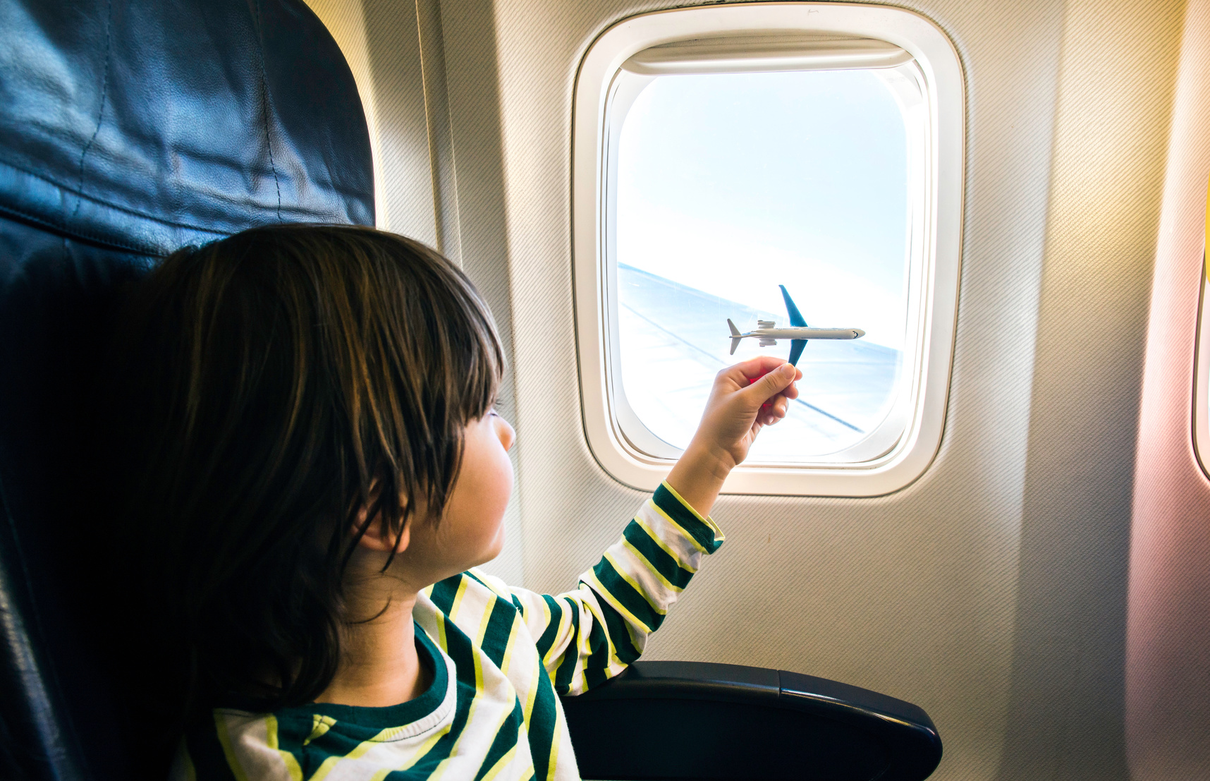 enfant dans un avion devant un hublot