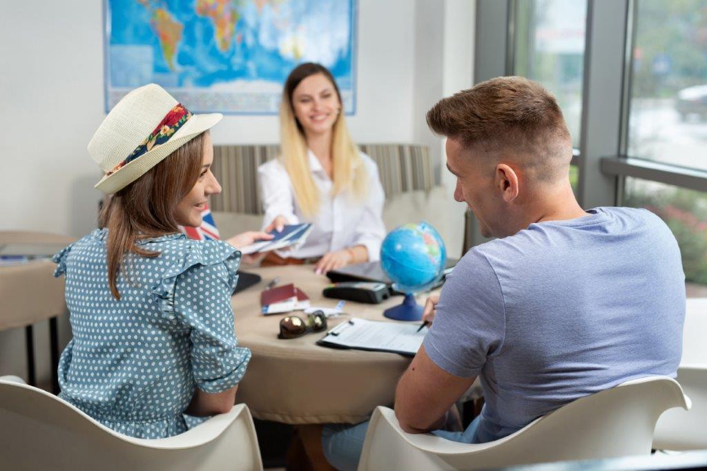 couple dans une agence de voyage avec conseillère