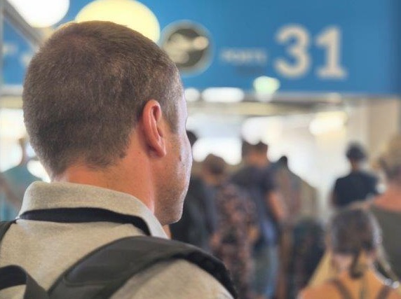 homme de dos devant porte embarquement